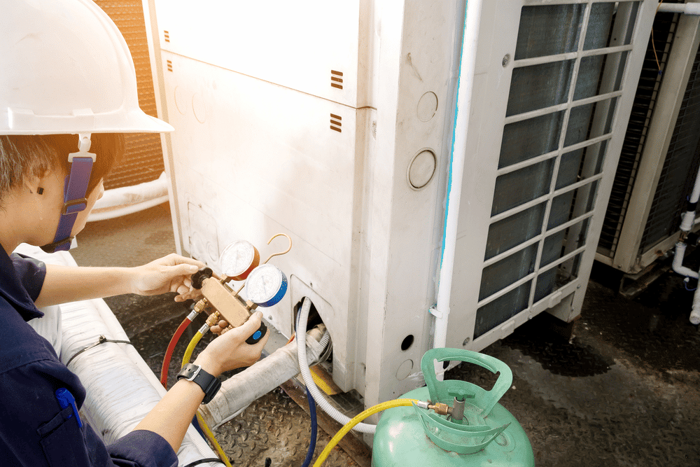 technician fixing an air conditioner freezing up outside unit